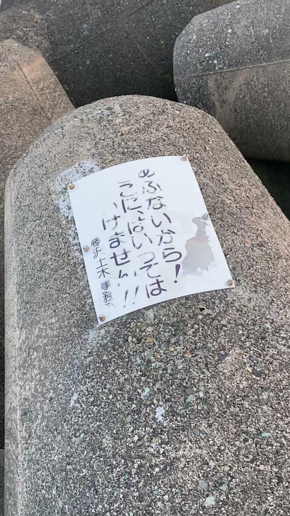 テトラに貼られた立ち入りを止める貼り紙